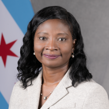 Headshot of Simbo Ige, in front of Chicago flag