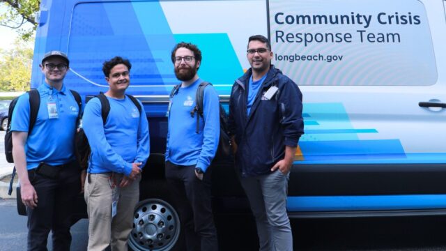 Four Long Beach HHS employees in front of a community crisis response team van
