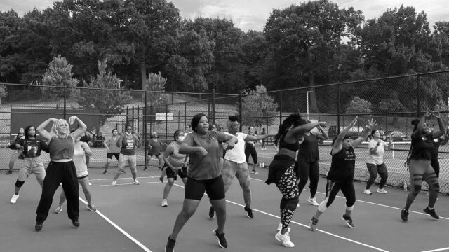 About 20 women participating in an outdoor fitness class